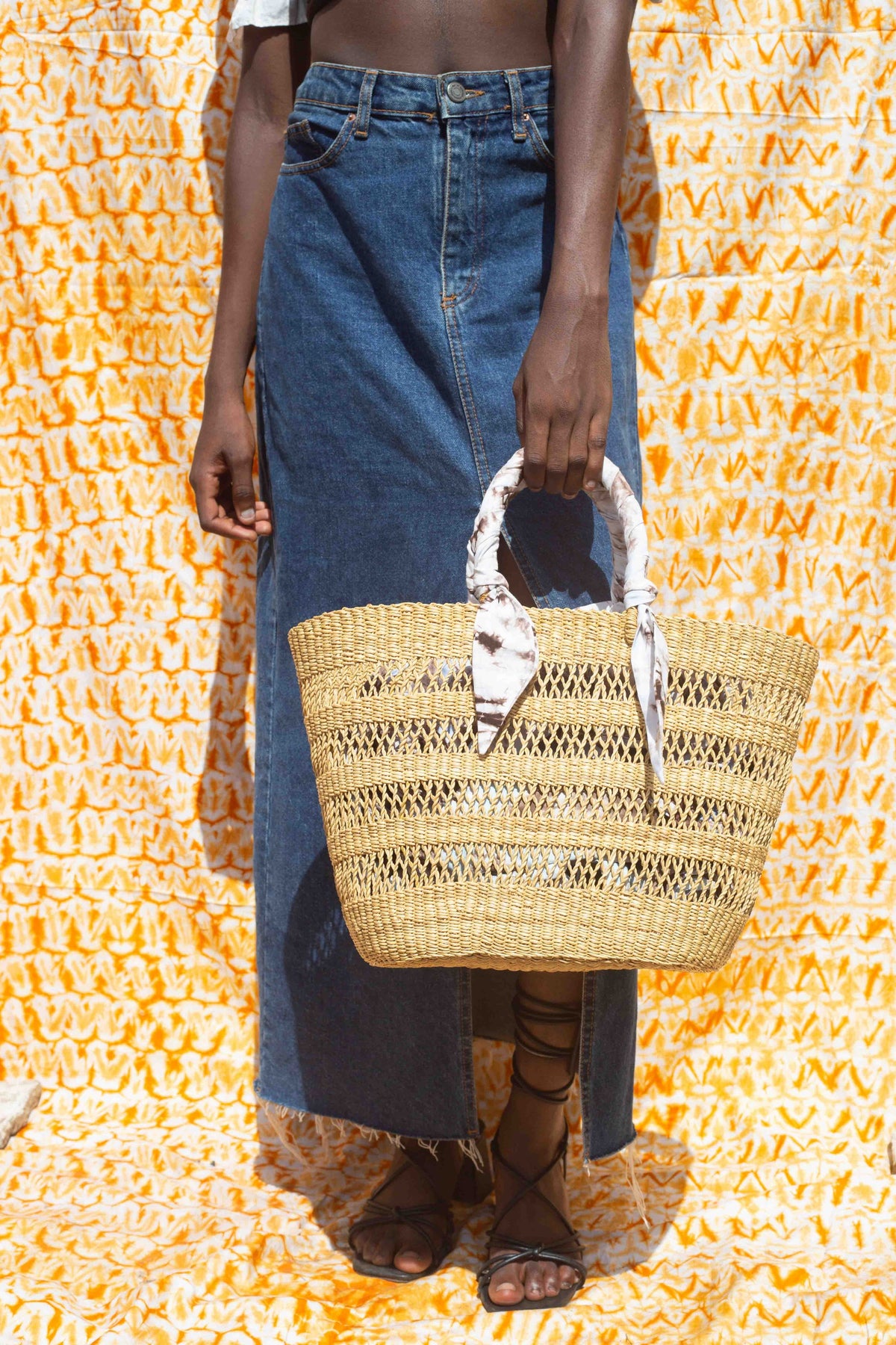 Eco-friendly Ghanaian tote bag, handwoven with tie-dye fabric accents.