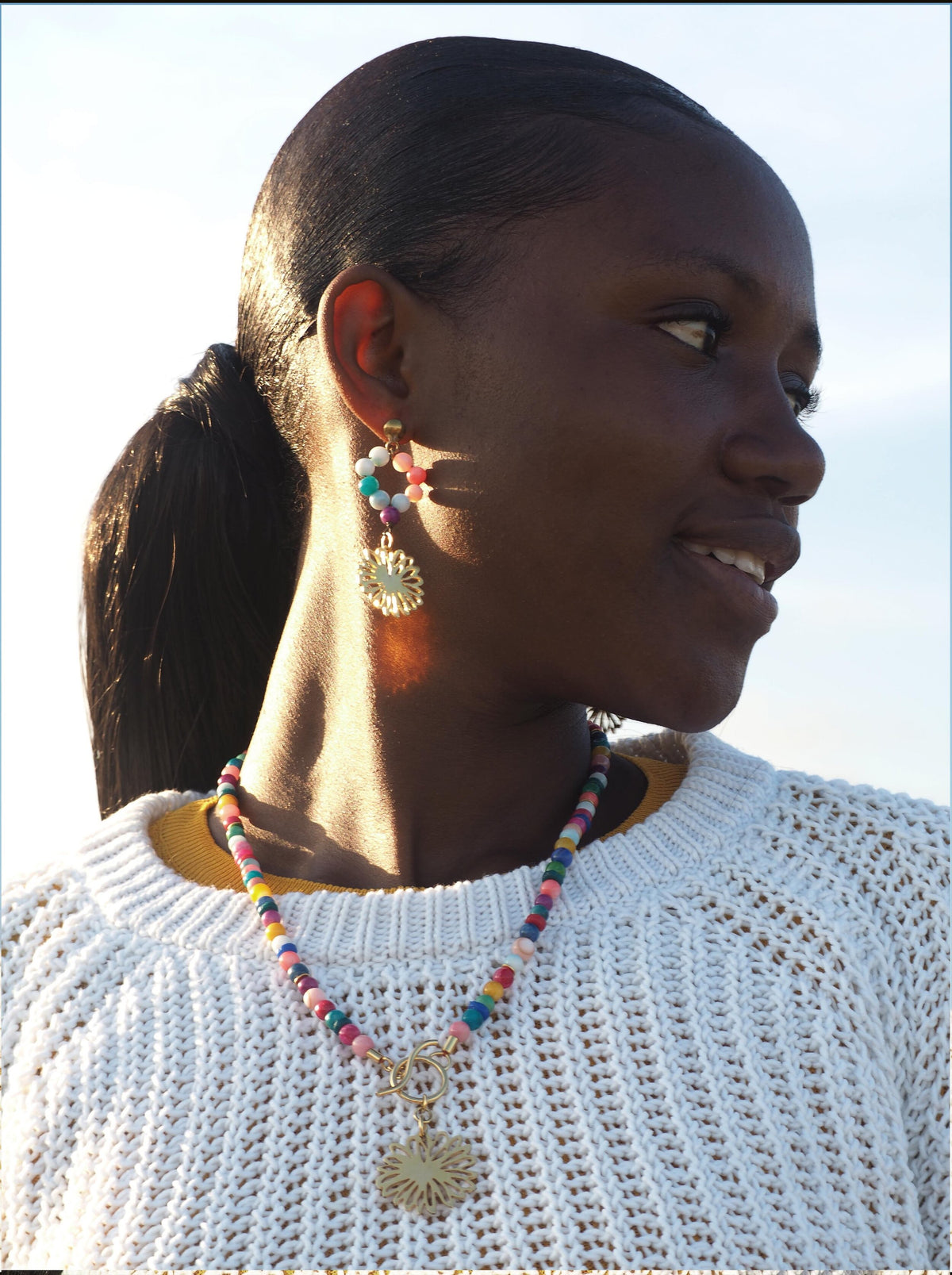 Bohemian-style bracelet with handcrafted colourful glass beads and a gold-plated amulet featuring a flower.