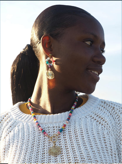 Bohemian-style bracelet with handcrafted colourful glass beads and a gold-plated amulet featuring a flower.