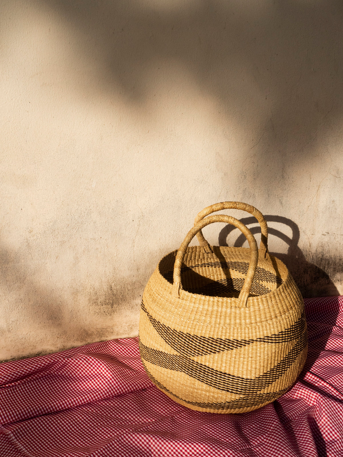 Decorative woven basket with intricate patterns, ideal for storage.