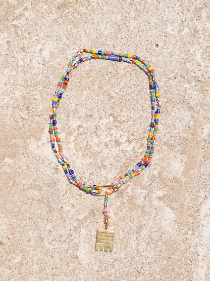 Handmade necklace with colorful recycled glass beads and Adinkra symbol amulet