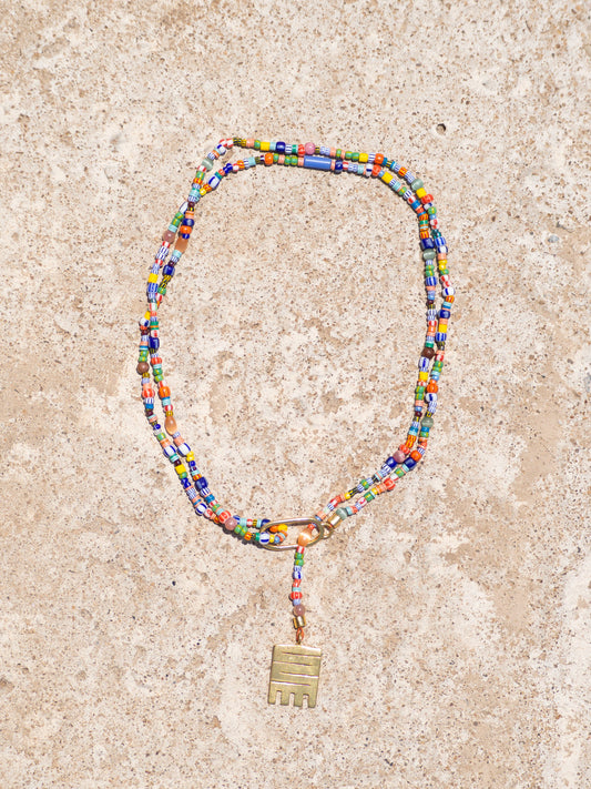 Handmade necklace with colorful recycled glass beads and Adinkra symbol amulet