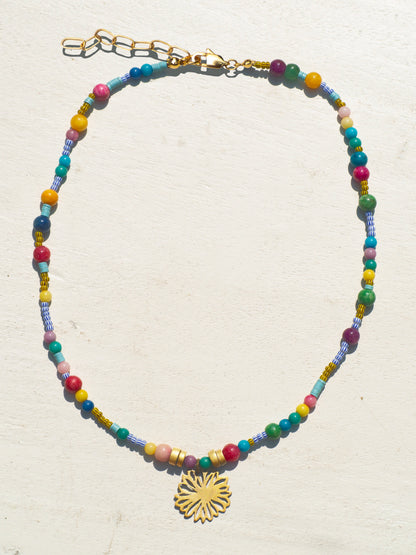 Bohemian-style necklace with african tribe beads and a gold-plated amulet featuring a flower.