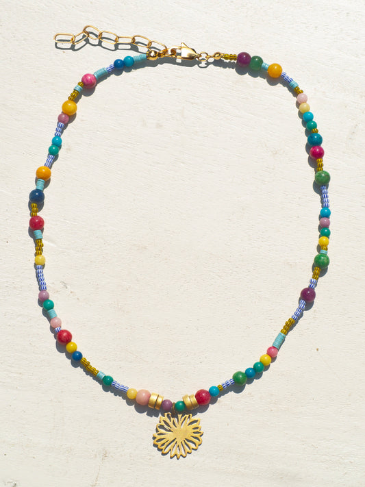 Bohemian-style necklace with african tribe beads and a gold-plated amulet featuring a flower.