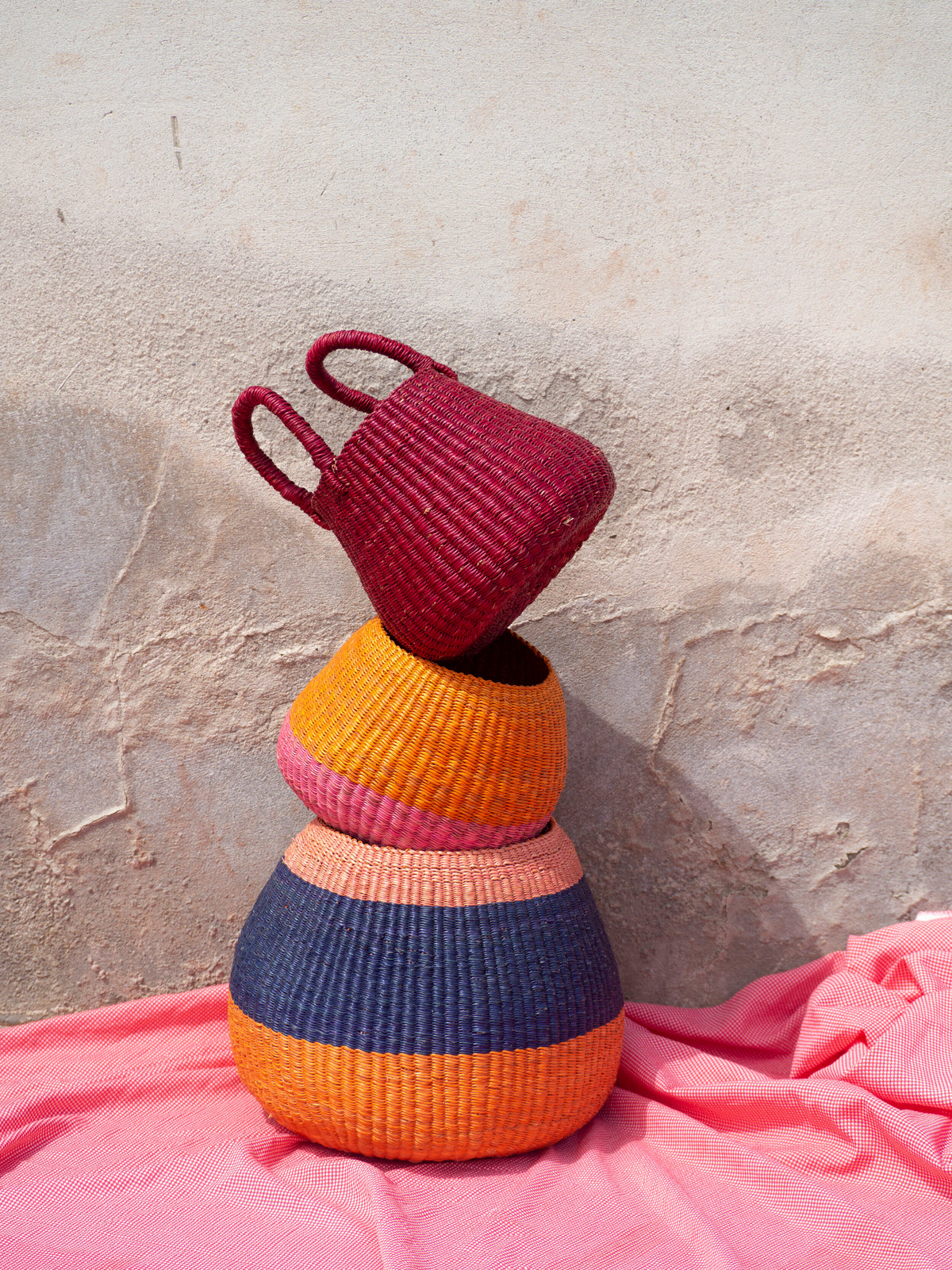 Eco-friendly straw storage basket in bold colours, ideal for organizing spaces with a rustic touch.