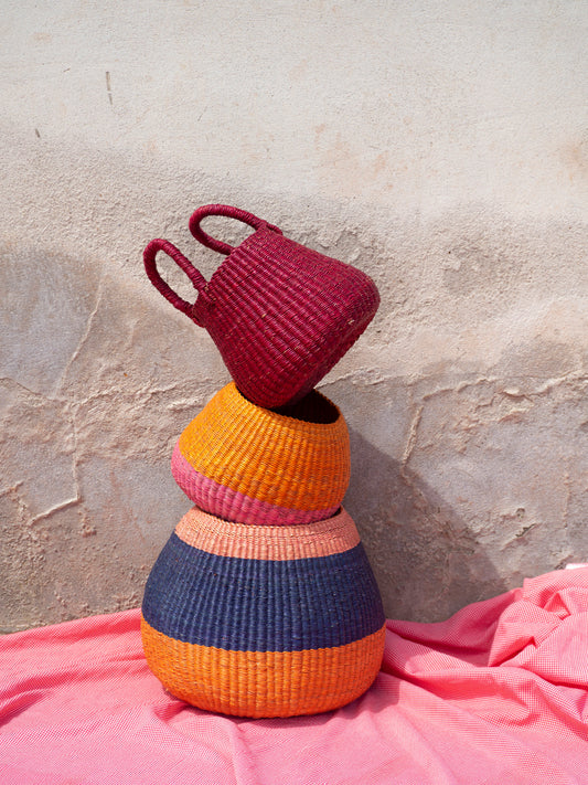 Eco-friendly straw storage basket in bold colours, ideal for organizing spaces with a rustic touch.