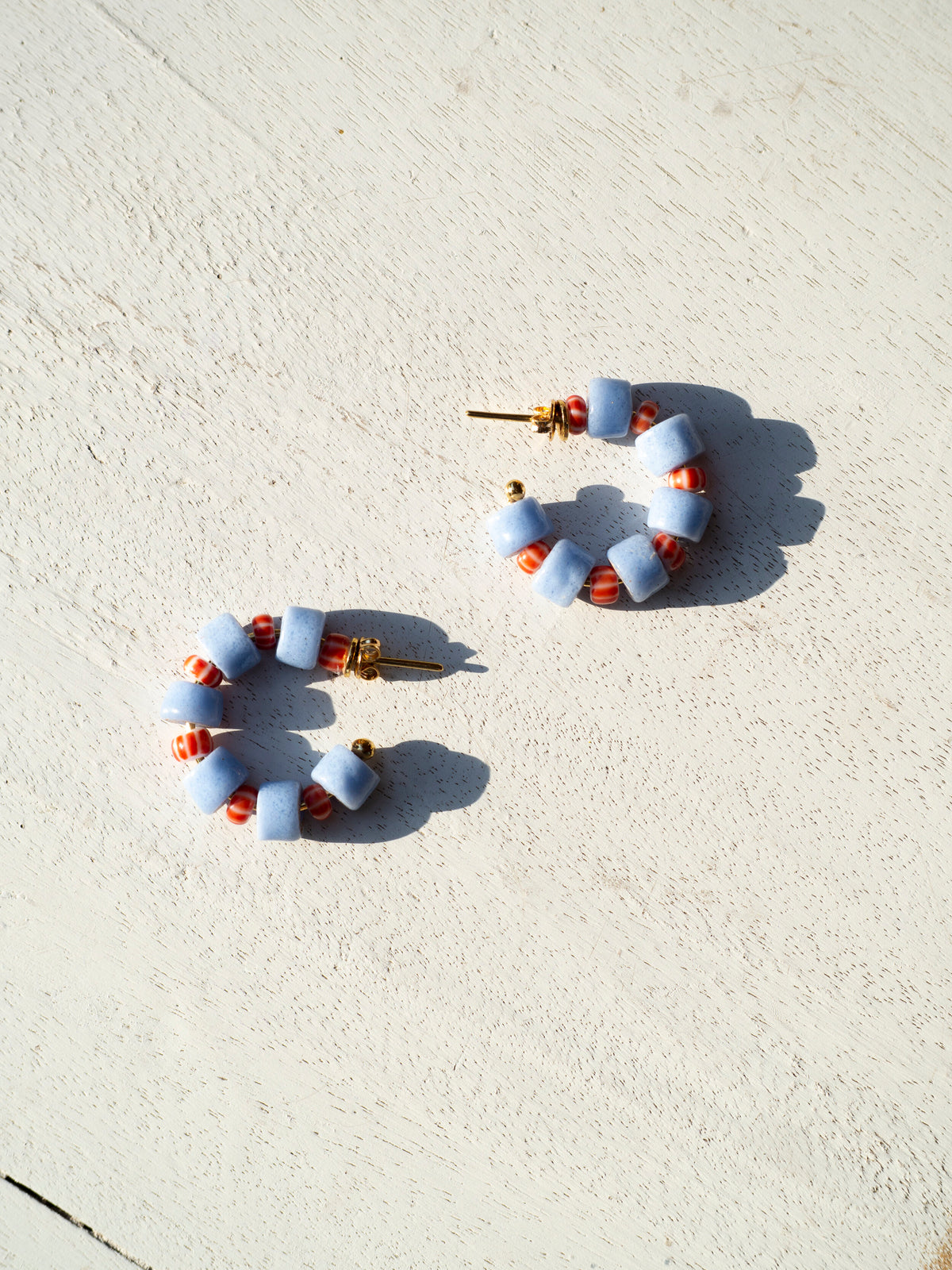 Boho-inspired earrings with recycled glass beads and gold-plated brass hoops.