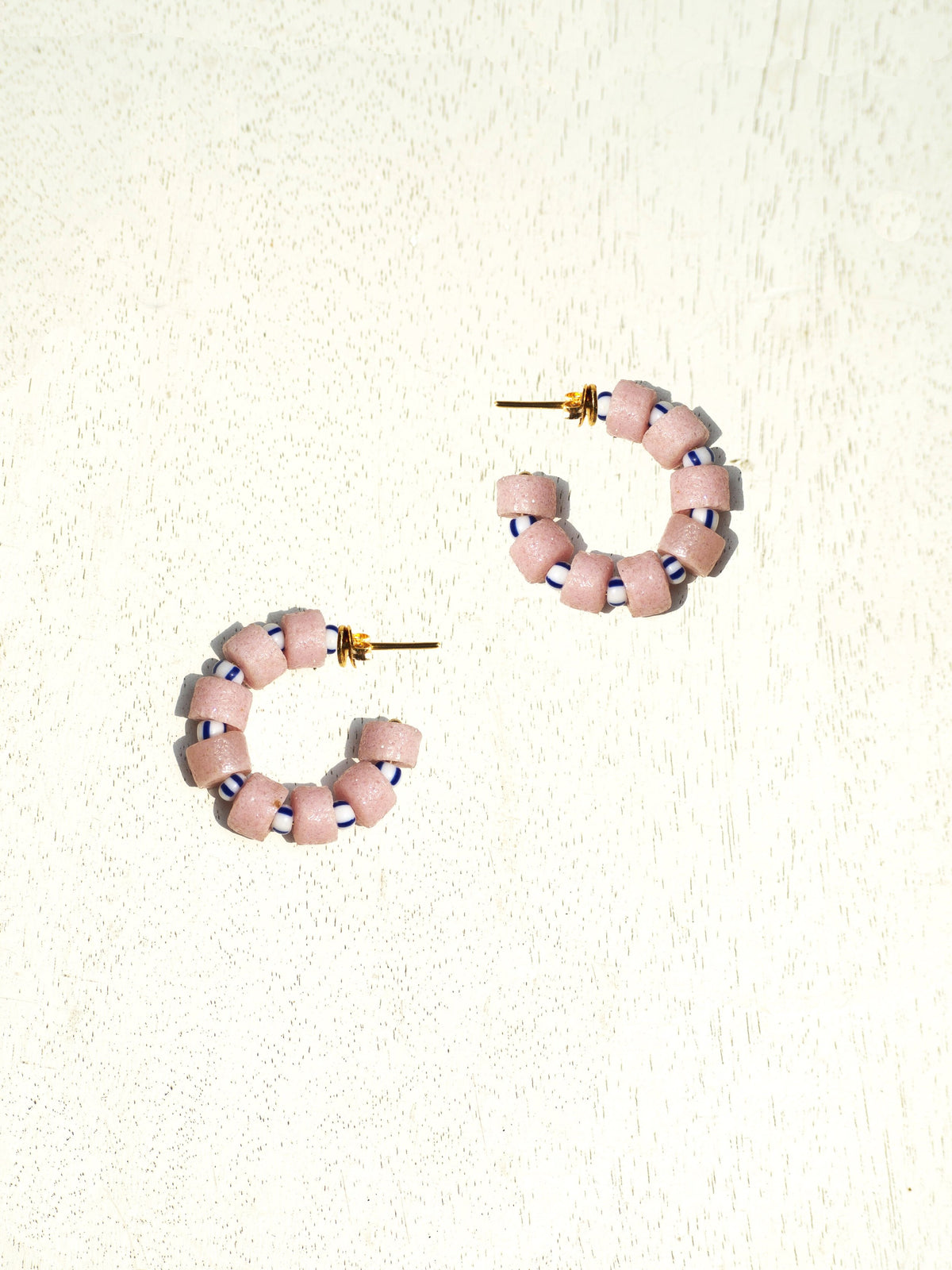 Boho-inspired earrings with recycled glass beads and gold-plated brass hoops.