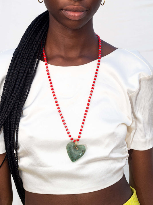 Statement necklace featuring Ghanaian heart-shaped recycled glass beads on a strand of unique red beads, combining vibrant colors and cultural craftsmanship.