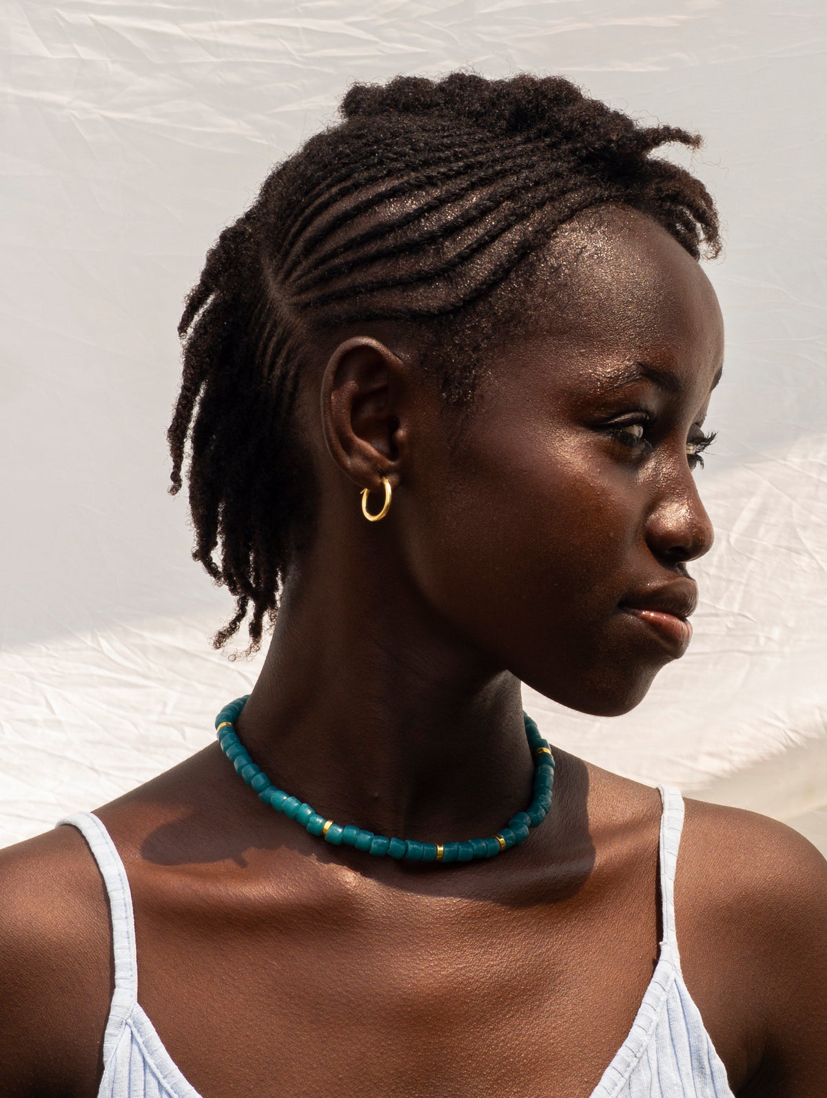 Hand-beaded necklace with colourful recycled glass beads and intricate gold-plated details.