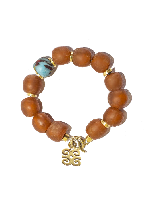 Handcrafted bracelet with rich, multicolored Ghanaian glass beads and gold-plated brass Adinkra symbol amulet